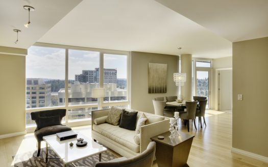 Sun shining through windows of open floor plan in luxury highrise apartment